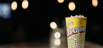 A cup of popcorn in a dark cinema